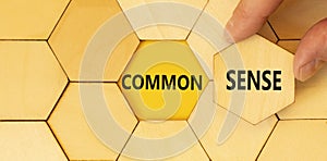 Common sense symbol. Concept words Common sense on beautiful wooden puzzle. Beautiful yellow background. Businessman hand.