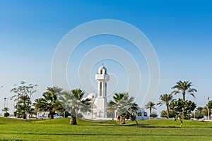 A common small mosque, Al Essa and Al Dowayan Mosque, with palm tree in the corniche coastal park in Dammam, Kingdom of Saudi photo