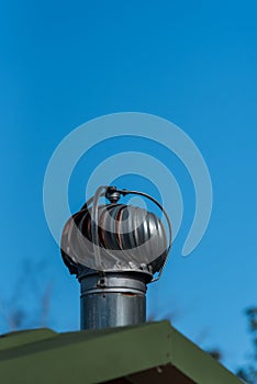 Common turbine exhaust vent on a bathroom roof with blue sky