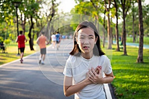 Communicates the symptoms of heart disease,immediately,Asian little girl with chest pain suffering from heart attack after run,