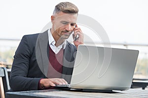 Communicating to world. Employee talk on phone working on laptop. Business communication. Using computer technology