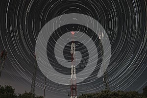 Communication antennas on the mountain and circumpolar stars at night