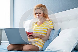 communication of cheerful girl with coffee and laptop. online communication of girl at home.