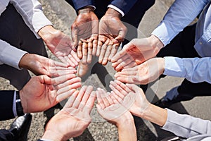 Communication among go-getters. Shot of a group of unrecognizable businesspeople joining their hands together outside.