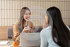 Communication and Interaction. A student animatedly discussing concepts with a classmate at the table.