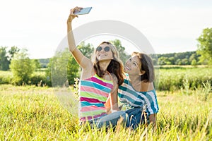 Communication between the mother and the teen daughter. Photos on a smartphone together.