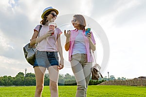 Communication of parent and teenager. Mother is talking to her teen daughter for 14 years, walking around the park on sunny summer