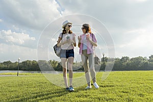 Communication of parent and teenager. Mother is talking to her teen daughter for 14 years, walking around the park on sunny summer