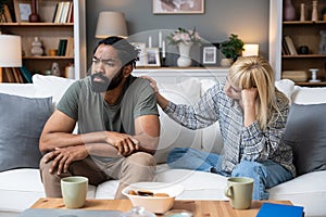 Communication problems, relationship difficulties. Young couple man and woman sitting on sofa at home, argue and misunderstanding