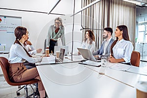 Communication and relaxed atmosphere during work.Young african business woman standing and talking with colleagues on the business