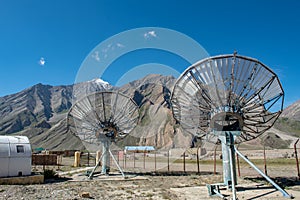 Communication satellite dishes network technology in rural area with the range of mountain and blue sky background