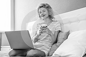 communication of smiling girl with coffee and laptop. online communication of girl at home.