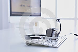 Communication support, call center and customer service help desk. VOIP headset on laptop computer keyboard