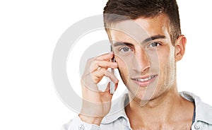 Communication through technology. A handsome male talking on his cell phone with a white background.