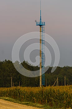 Communication tower on the background of twilight in the field