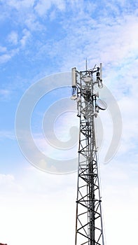 Communication tower network antenna for cellular telephone with blue cloudy sky