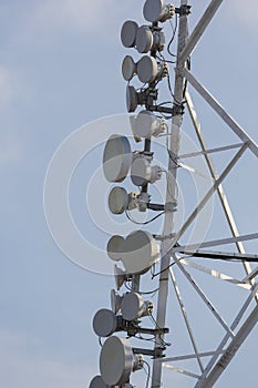 Communication tower and satellite dishes on blue sky background
