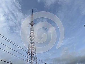 Communication tower under the cloudy sky.