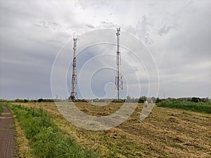 Communication towers on the background of an agricultural field
