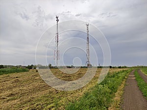Communication towers on the background of an agricultural field