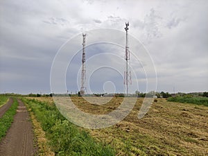 Communication towers on the background of an agricultural field