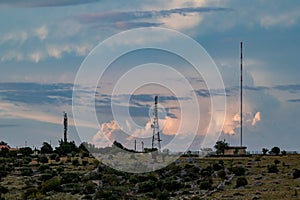 Communication towers and cloudy sunset sky