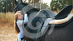 Communication - young girl and bay horse in wood