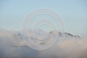 Communications antenna over the mountains and surrounded by clouds