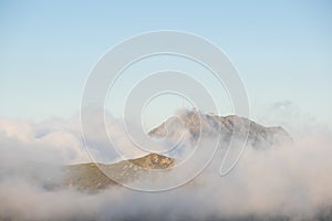 Communications antenna over the mountains and surrounded by clouds.