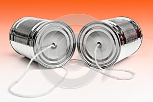 Communications and business calls concept of tin can telephone with string on orange