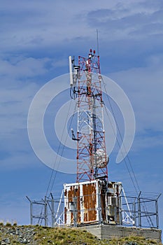 Communications cellular telecoms communications antenna in the top of the mountains with rusty communication shelter . photo