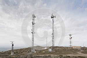 A communications center on top of a hill with large, tall antennas. Big Data.