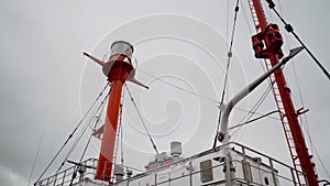 Communications masts of a ship red color. Radio antena on the ship bridge during murky day.