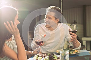 Communicative boyfriend with light stubble eating salad and talking with girl