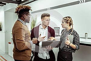 Communicative colleagues standing in corridor and solving problems