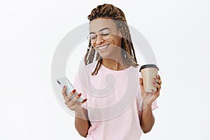 Communicative sociable good-looking modern dark-skinned female student with dreadlocks in pink t-shirt and glasses