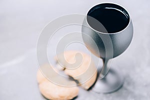 Communion still life. Unleavened bread, chalice of wine on grey background. Christian communion concept for reminder of Jesus