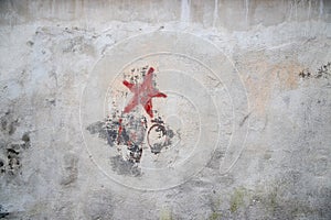 Communistic symbol: Grungy red star graffiti on and old wall