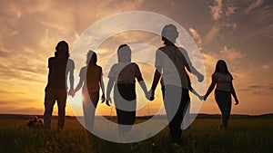 Community big family in the park. Large group of lifestyle people holding hands walking silhouette nature in the park