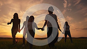 community big family in the park. large group of lifestyle people holding hands walking silhouette nature in the park