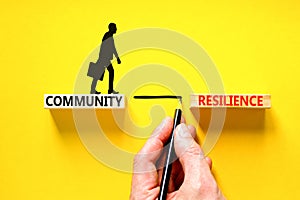 Community resilience symbol. Concept word Community resilience typed on wooden blocks. Beautiful yellow table yellow background.