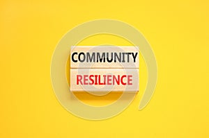 Community resilience symbol. Concept word Community resilience typed on wooden blocks. Beautiful yellow table yellow background.