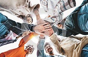 Community of young people stacking hands together - Multiracial college students putting their hands on top of each other