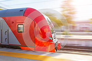 Commuter train travels at high speed through the passenger city station, head carriage, driver`s cab side view