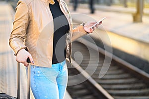 Commuter using smartphone in train station.