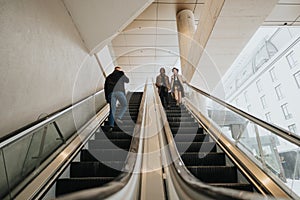 Commuters on an escalator inside a modern urban building space