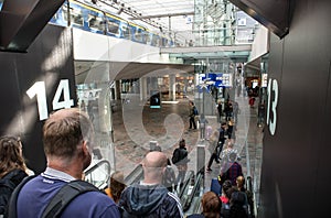 Commuters passengers on escalator inside a modern railway station terminal