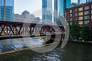 Commuters rush across the Lake Street bridge as bright summer morning light  shines a spotlight on them in Chicago