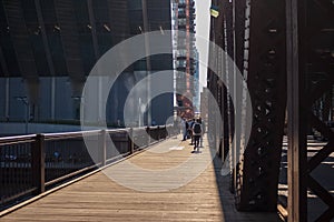 Commuters walk in the bright sunlight on the Lake St bridge over the Chicago River in the Loop