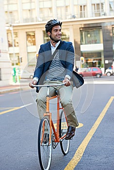 Commuting the carbon-free way. a handsome businessman traveling to work by bicycle in the city.